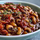 A bowl of Greek-Style Slow Cooker Black-Eyed Peas topped with crumbled feta, fresh parsley, and a drizzle of olive oil.