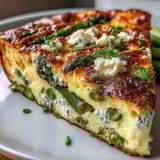 Saftige Spargel-Erbsen-Frittata, bestreut mit cremigem Ziegenkäse, duftend und leicht.